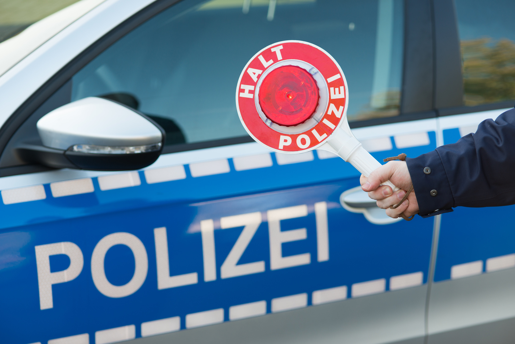 Polizeikelle vor Polizeiauto