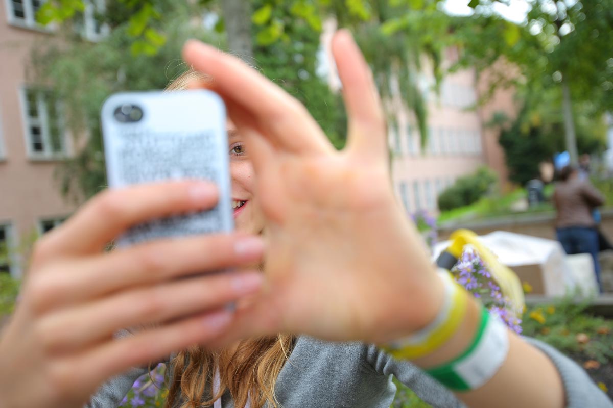 Junge Frau mit Smartphone macht ein Foto